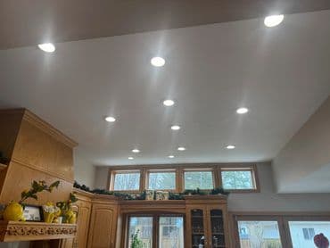 Modern kitchen with recessed lighting and large windows for natural light.